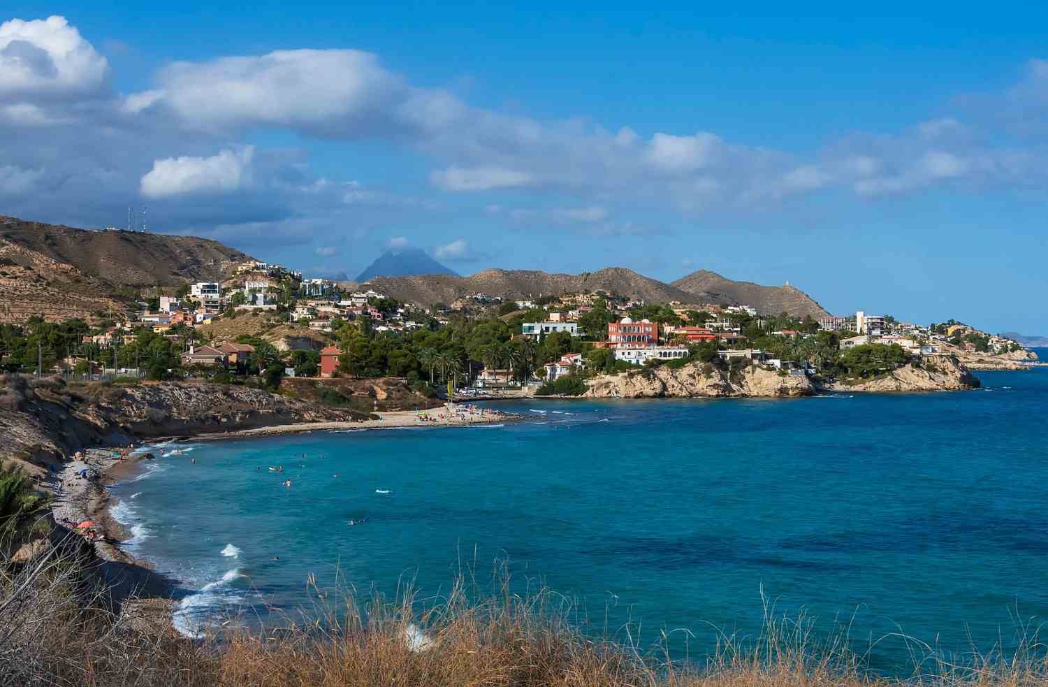 Costa y montañas bajo cielo